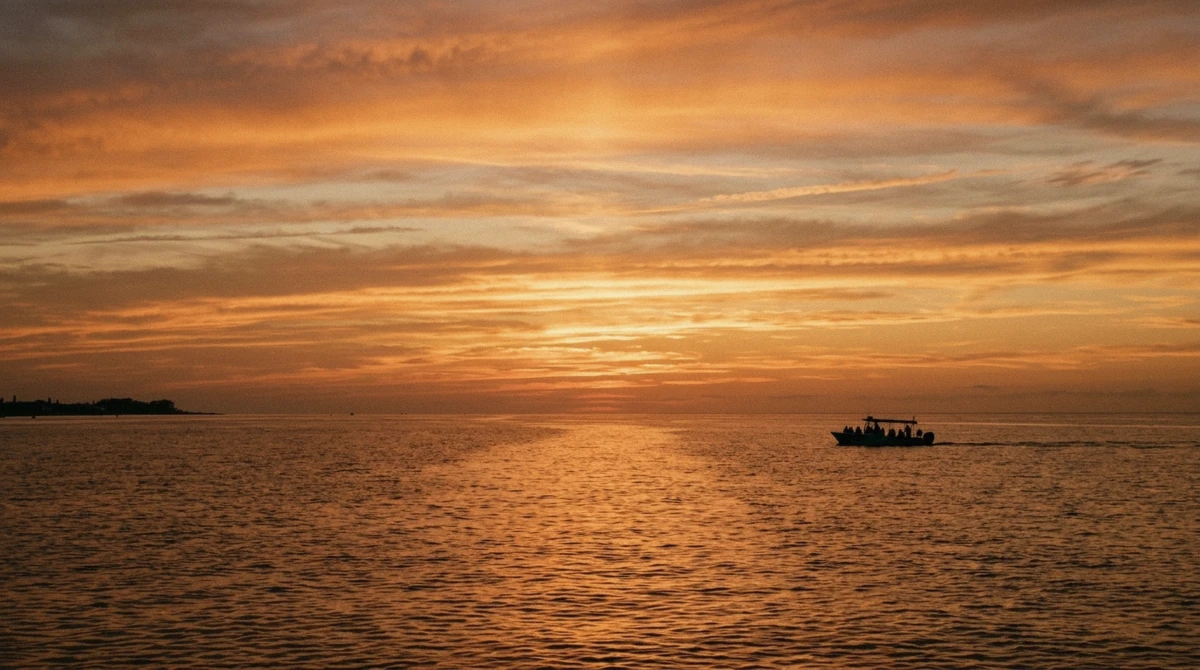 Low sun over the Gulf of Mexico with a tour boat silhouetted on the water during a sunset Anna Maria Island dolphin tour